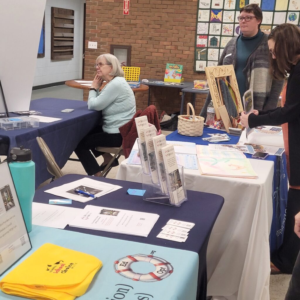 woman sitting at table and people standing at table
