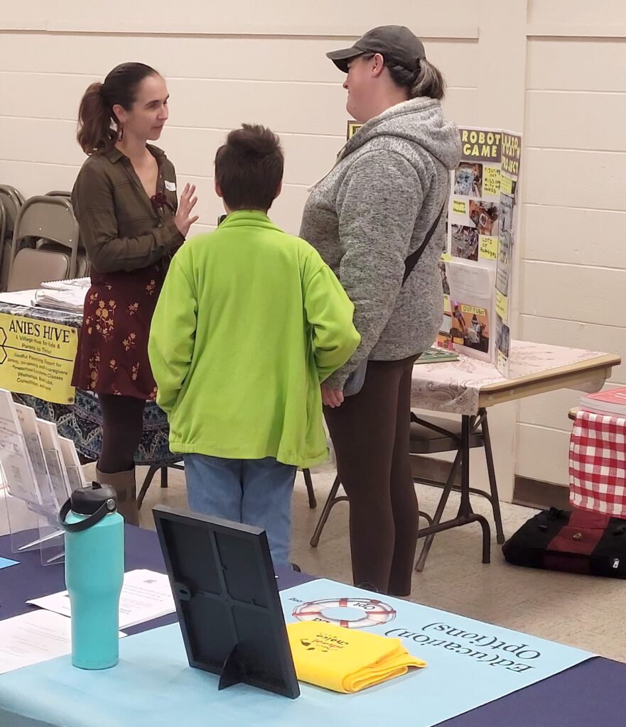 Family engaging with woman in front of table