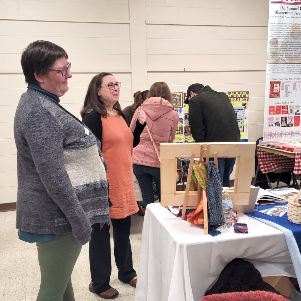 Two women standing at education table