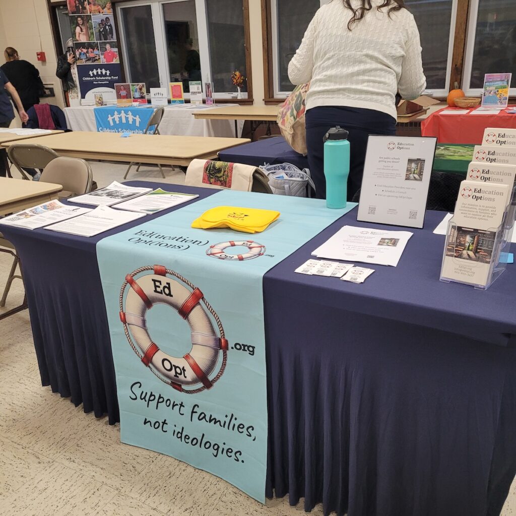 table at indoor education fair with EdOpt logo on table runner
