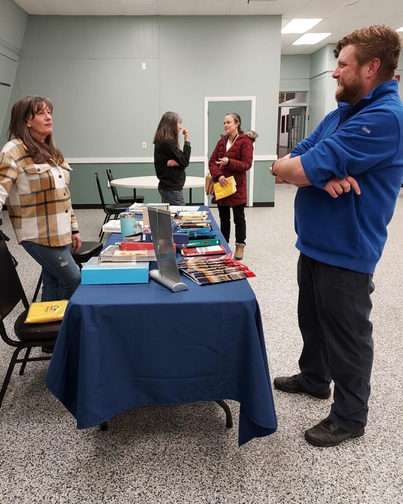 People chatting around a table at a fair