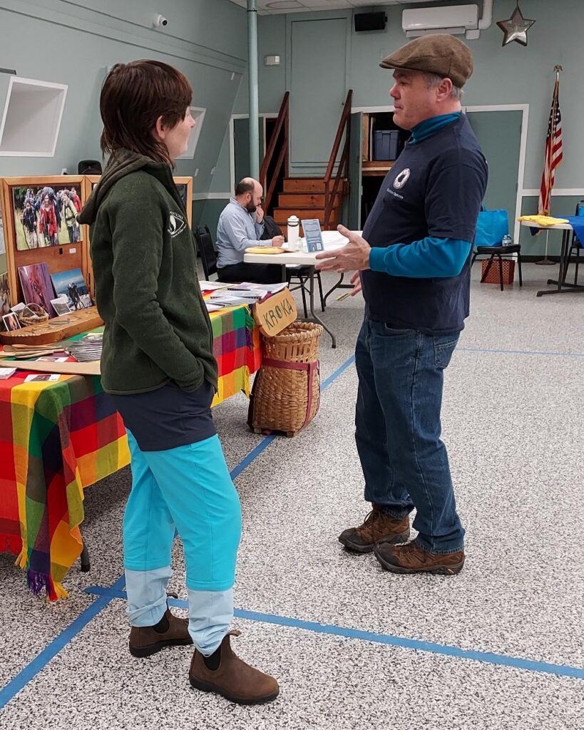 People chatting around a table at a fair