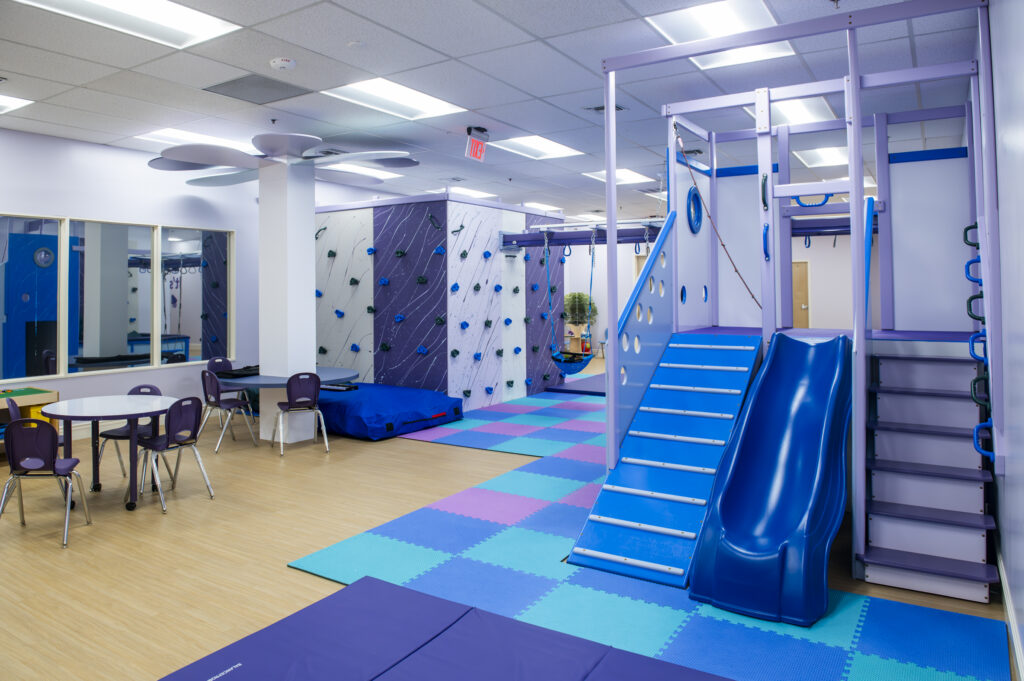 Blue slide, tables and chairs, climbing facilities and swings.