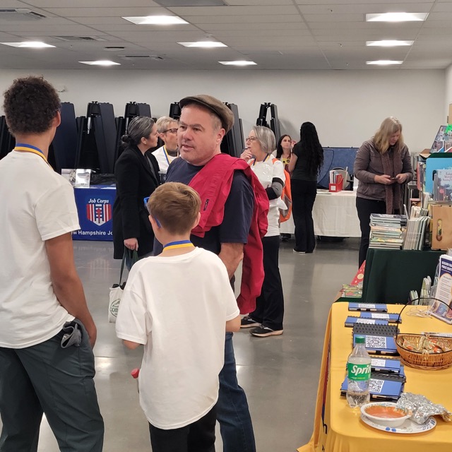 Adults and children explore information tables and book displays at the Loudon education fair.