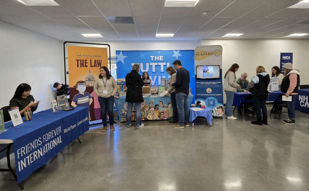 Visitors explore Friends Forever International, Tuttle Twins, and Classical Conversations tables at the Loudon education fair.